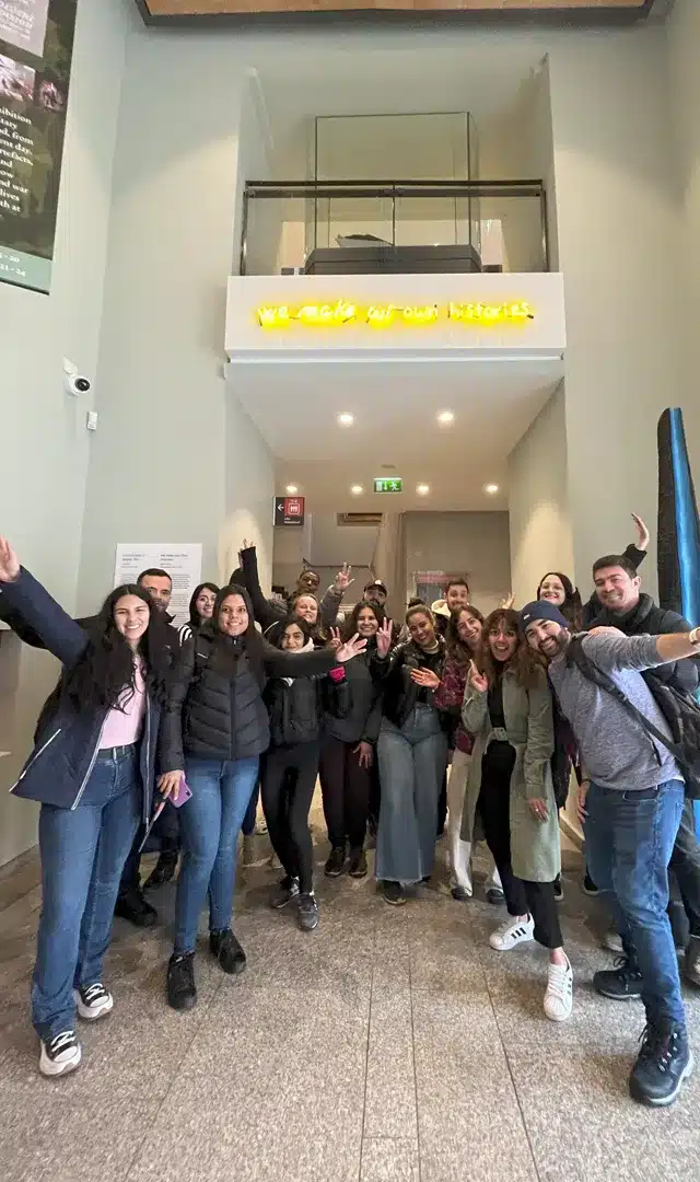 Delfin students posing together with school flag during social activity